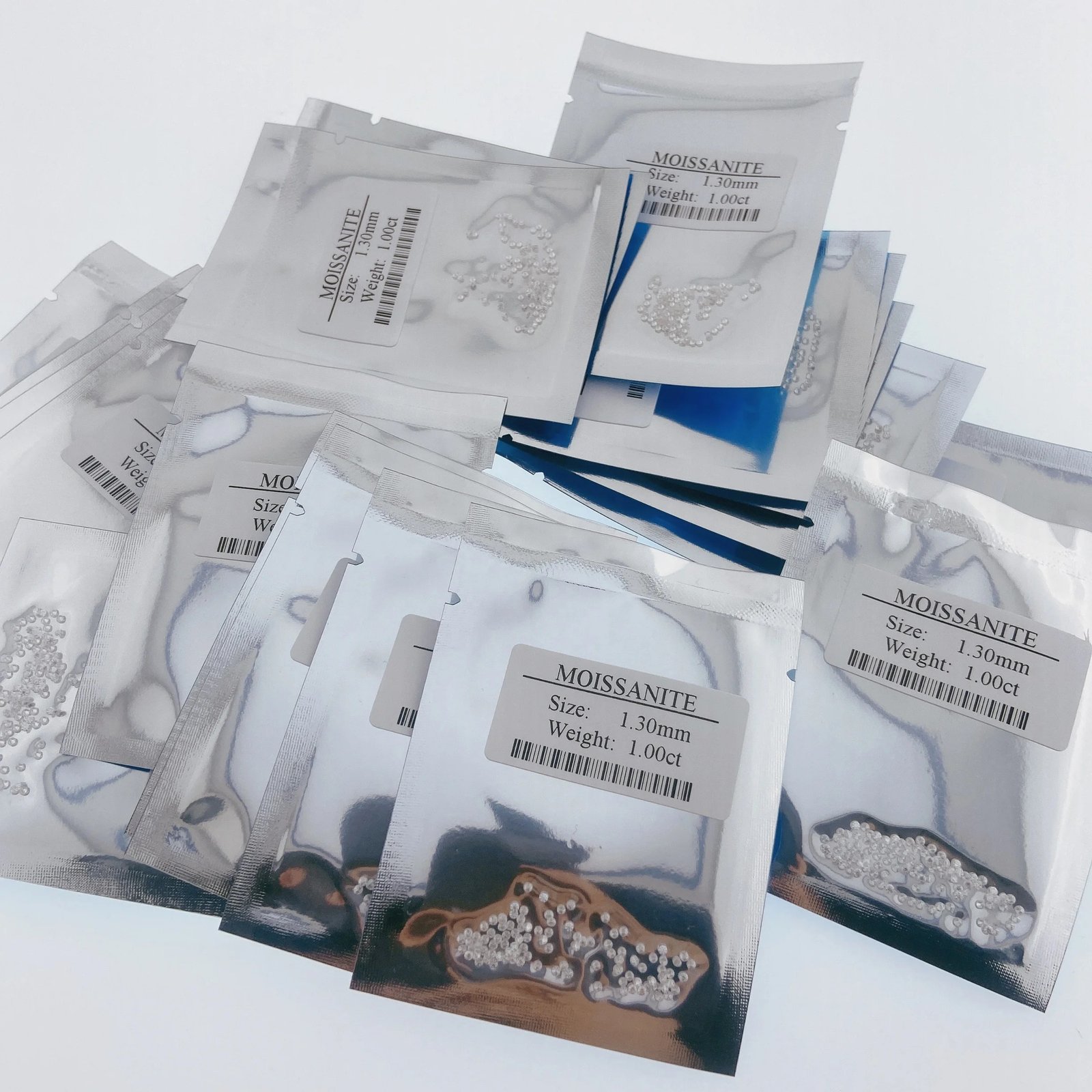 Labeled moissanite export packets with size and weight stickers — receiving-ready packaging